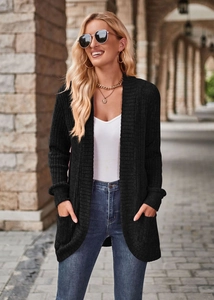 Close-up of black ribbed knit long cardigan featuring functional front pockets and soft texture