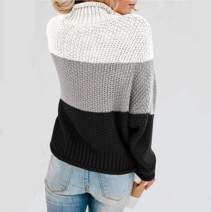 Detail der groben Strickstruktur und Farblockierung in Weiß, Grau, Schwarz am Rollkragen