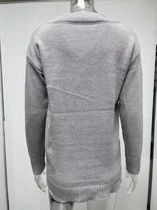 Detail of grey V-neck knit sweater featuring ribbed cuffs and a minimalist refined texture