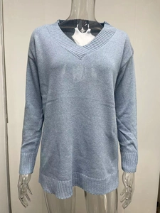 Detail view of the V-neckline and rib-knit cuffs on this blue long-sleeved sweater