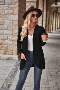 Detail of black ribbed knit cardigan featuring practical side pockets and long sleeves