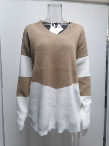 Close-up of V-neck knit sweater showing camel and white color block and ribbed textures