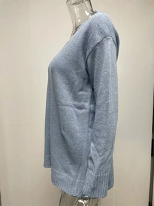 Detail of light blue V-neck knit sweater featuring ribbed hem and fine stitch texture