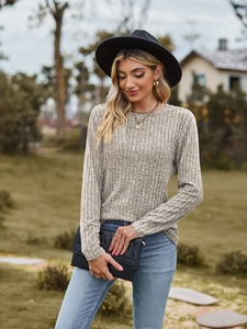 Detail of light gray ribbed knit long sleeve top with crew neck and vertical texture