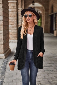 Detail of black ribbed knit cardigan featuring side patch pockets and soft textured fabric