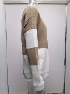 Detail of color-block knit sweater showing ribbed cuffs and fine stitching texture