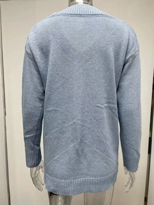 Detail view of light blue knitted sweater back showing ribbed cuffs and soft texture