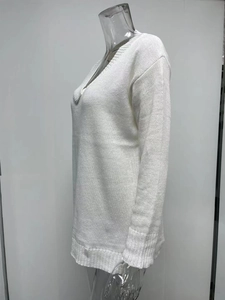 Detail of white V-neck knitted sweater showing the rib-knit texture and long sleeves
