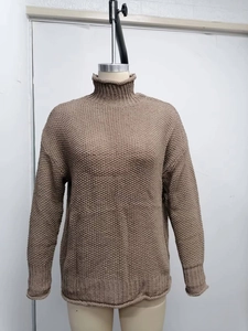Detalle de jersey de cuello alto en punto grueso marrón café con puños acanalados suaves
