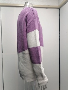 Detail of color-block knit texture in purple and white on a casual loose sweater