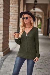 Dettaglio top a maniche lunghe in maglia a coste verde scuro con cerniera a V in argento