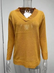 Detail of V-neck mustard yellow fine knit sweater with ribbed cuffs and hemline
