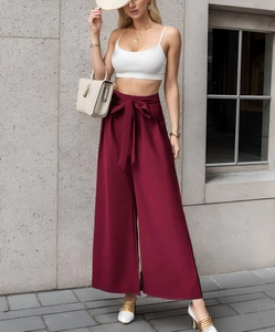 Vue détaillée du pantalon large taille haute bordeaux avec une ceinture à nœud élégante