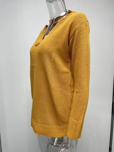 Detail view of ginger yellow V-neck knit sweater featuring ribbed cuffs and hem textures
