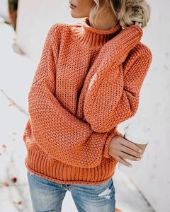 Detail der groben Strickstruktur und des hohen Rollkragens am orangen Pullover