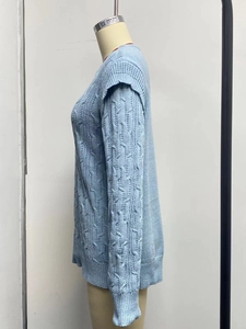 Detail of light blue cable-knit texture on thick loose-fit long sleeve crewneck sweater
