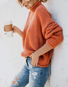 Detailaufnahme von orangefarbenem Grobstrick-Rollkragenpullover mit warmer Textur