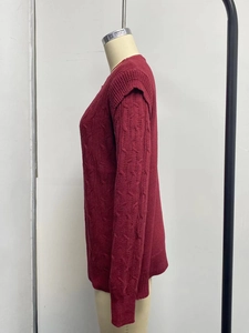 Detailed side view of burgundy cable knit sweater with thick texture and drop shoulder design