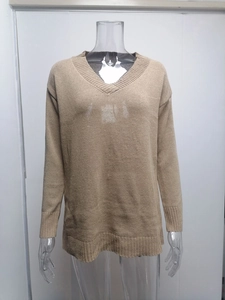 Detail view of khaki V-neck knitted sweater featuring ribbed cuffs and a classic hemline
