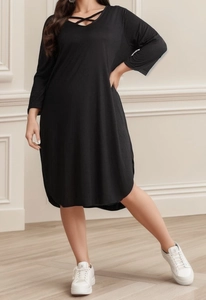 Detail of cross-strap neckline on a loose black long-sleeve cotton blend dress