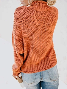 Detailansicht des grob gestrickten orangefarbenen Pullovers mit dickem Strickmuster