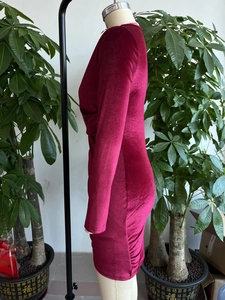 Détail de la robe en velours bordeaux montrant la texture froncée et le drapé