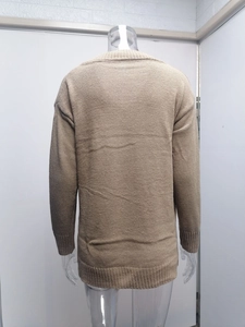 Detail of ribbed knit cuffs and neckline on a solid light brown V-neck sweater