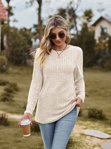 Detail of ribbed knit texture on a beige long-sleeve slim-fit top for women