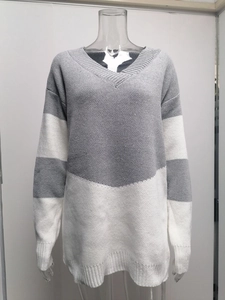 Close-up of V-neck knitted sweater featuring grey and white striped chunky rib texture