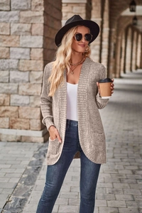 Detailed texture of light grey ribbed knit cardigan with front pockets for autumn