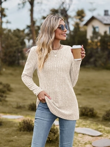 Detail showing creamy rib-knit fabric texture with side slit hem on a long sleeve top