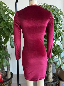Détail d'une robe moulante bordeaux en velours à manches longues avec une coupe ajustée