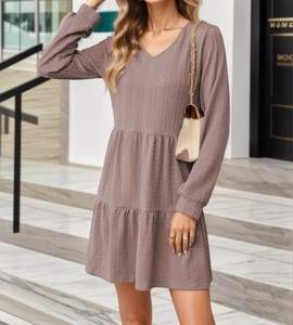 Detail view of the tiered hem and wave textured fabric on this V-neck mauve long sleeve dress