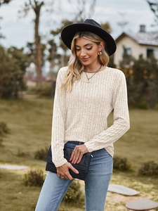Detail of ribbed knit texture on a beige crewneck long sleeve t-shirt worn outdoors