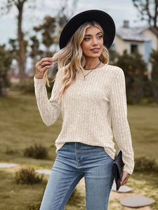 Detail of ribbed knit texture on cream crewneck long sleeve top worn by a model outdoors
