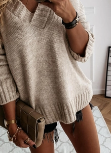 Macro view of beige knit sweater showing plush texture and deep V-neckline details