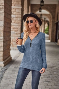 Dettaglio del tessuto a costine e del colletto con zip sulla maglia grigio-blu