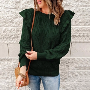 Detail of cable knit texture and ruffle trim on dark green sweater shoulder