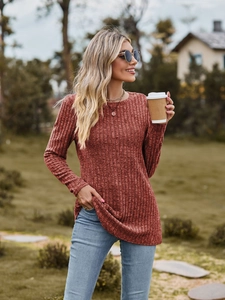 Close-up of ribbed texture and crew neck on a rust red long sleeve knitted shirt