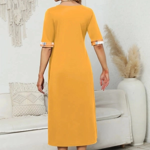 Detail view of mustard yellow midi dress featuring stylish plaid patchwork sleeves