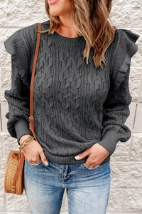 Detail of grey cable knit sweater featuring stylish ruffle shoulders and crew neck texture