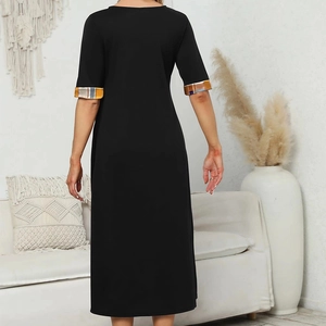 Rear view of black midi dress featuring contrasting plaid cuffs in home setting