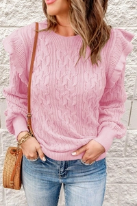 Detailed close-up of the ruffled shoulders and cable knit texture on this pink sweater