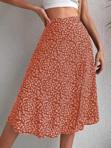 Detailed close-up of high-waist floral midi skirt with side slit in brick red and white