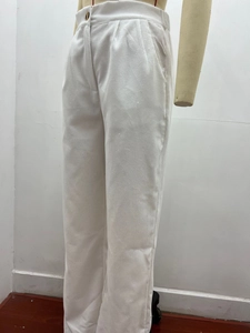 Detailed texture of off-white corduroy high-waisted trousers with button closure