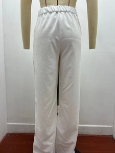 Close-up of white corduroy pants showing elastic high waist and fine ribbed texture