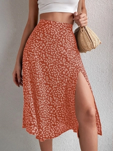 Detail of rust orange floral midi skirt with side slit and daisy print pattern