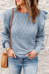 Detail of cable knit texture and ruffle shoulder trim on a light blue sweater