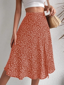 Detail of floral A-line skirt with daisy print and side slit in brick red summer fabric