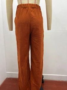 Close-up of caramel corduroy trousers showing vertical texture and elastic high waistband
